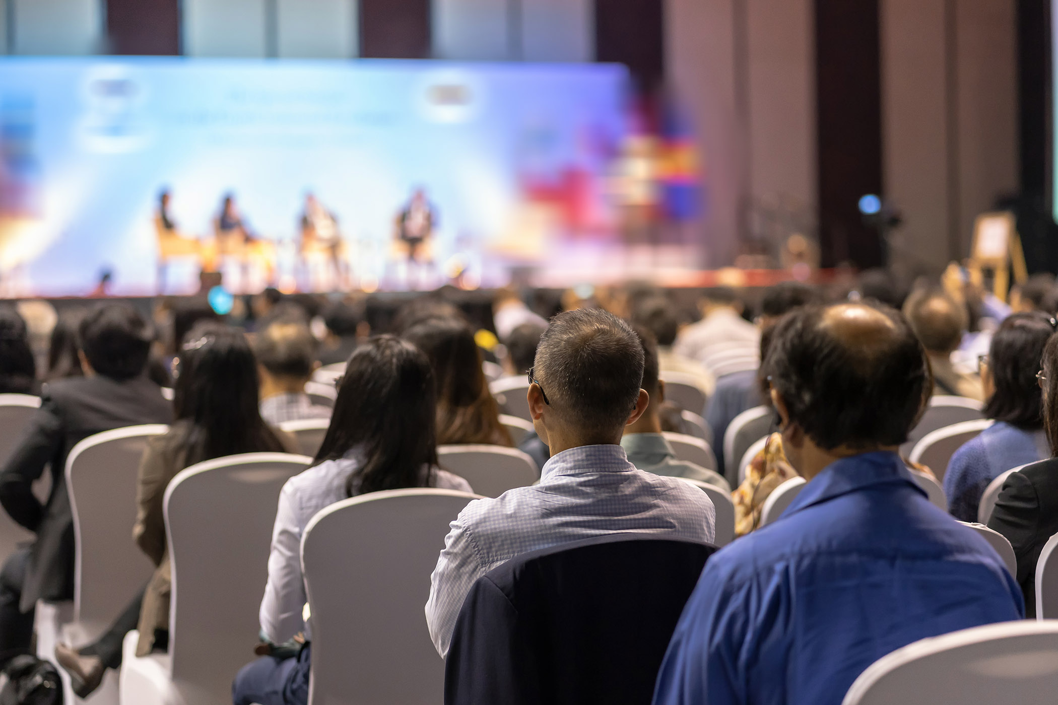 Rear view of Audience listening Speakers on the stage in the conference hall or seminar meeting, business and education about investment concept